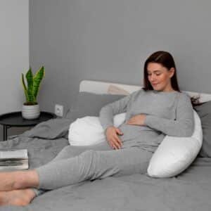 a pregnant woman using a pregnancy pillow