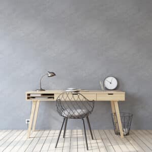wooden desk near empty gray wall