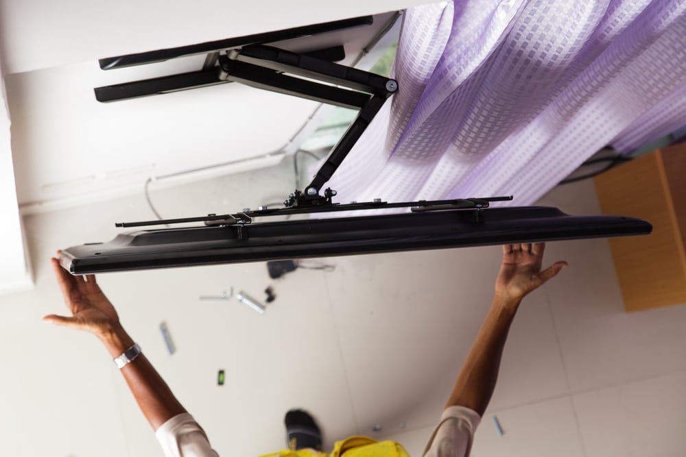 Man installing mount for television