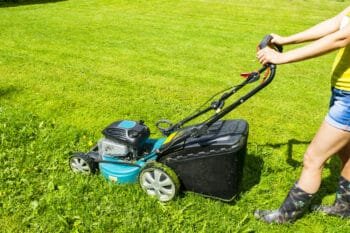 a woman mowing grass