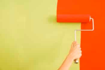 a woman painting a room with orange