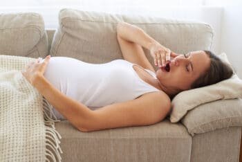 sleepy pregnant woman lying on back