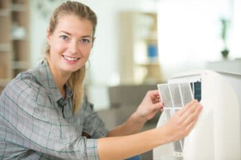 woman removing AC filter