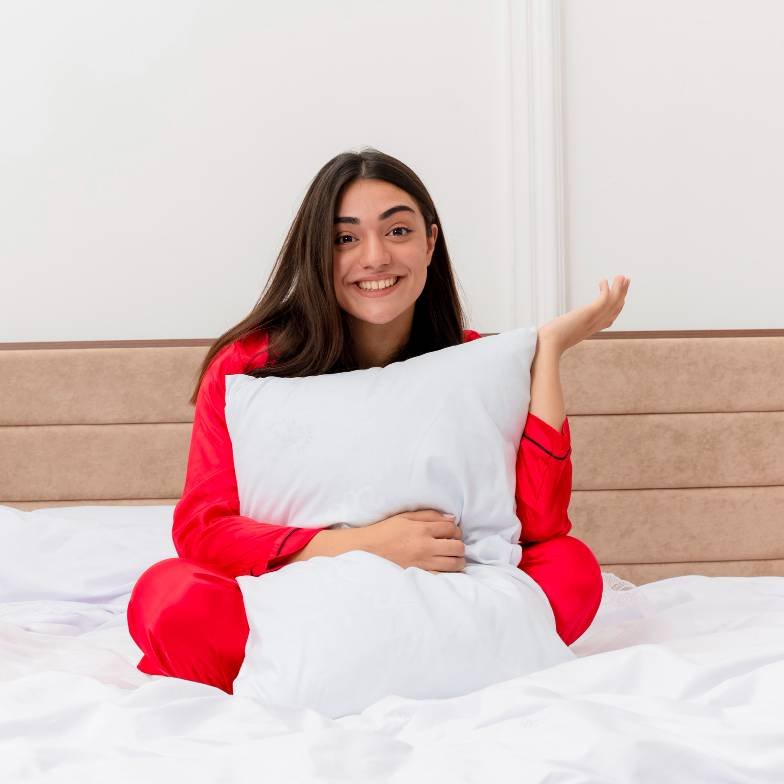 a beautiful lady in red pyjamas sitting in bed