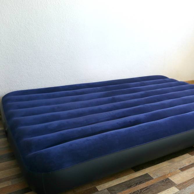 a blue air inflatable mattress on the floor