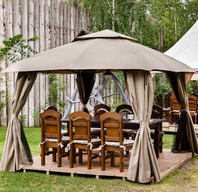 a canvas tent with wooden table and chairs