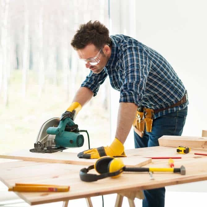 a carpenter cutting boards with a circular saw