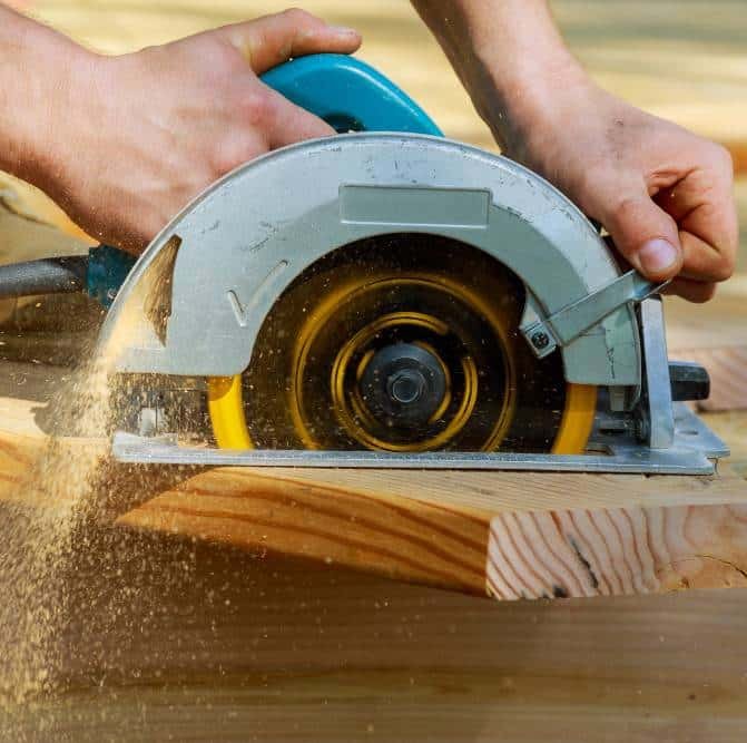 a carpenter using a circular saw for wood beam