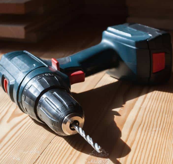 a cordless drill on the wooden table