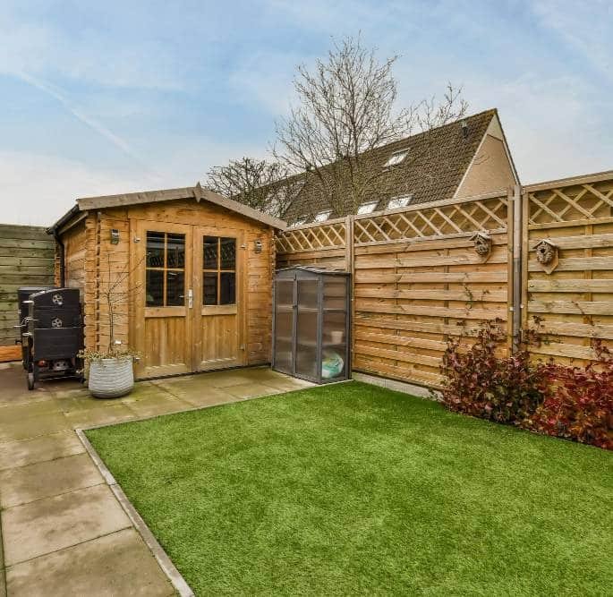 a cosy backyard with a small lawn and a shed
