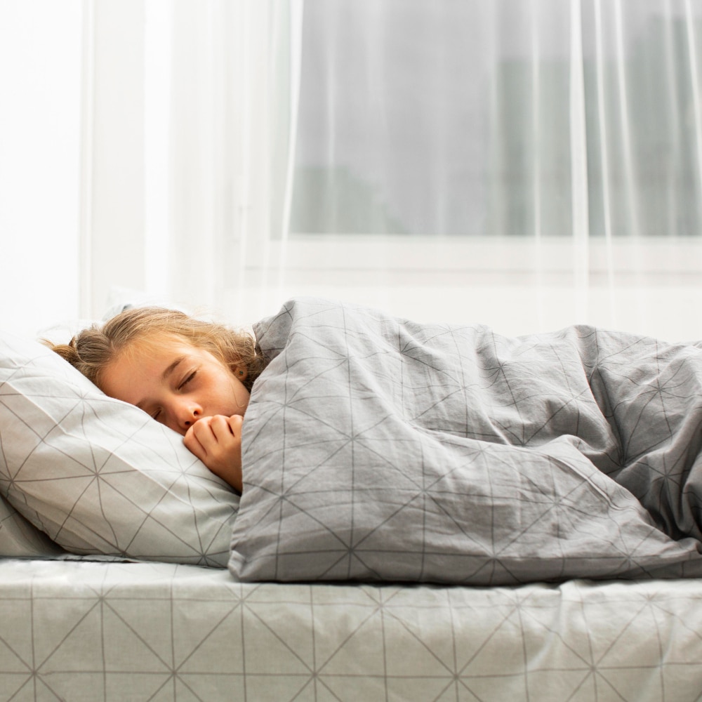 a girl using a weighted blanket in bed