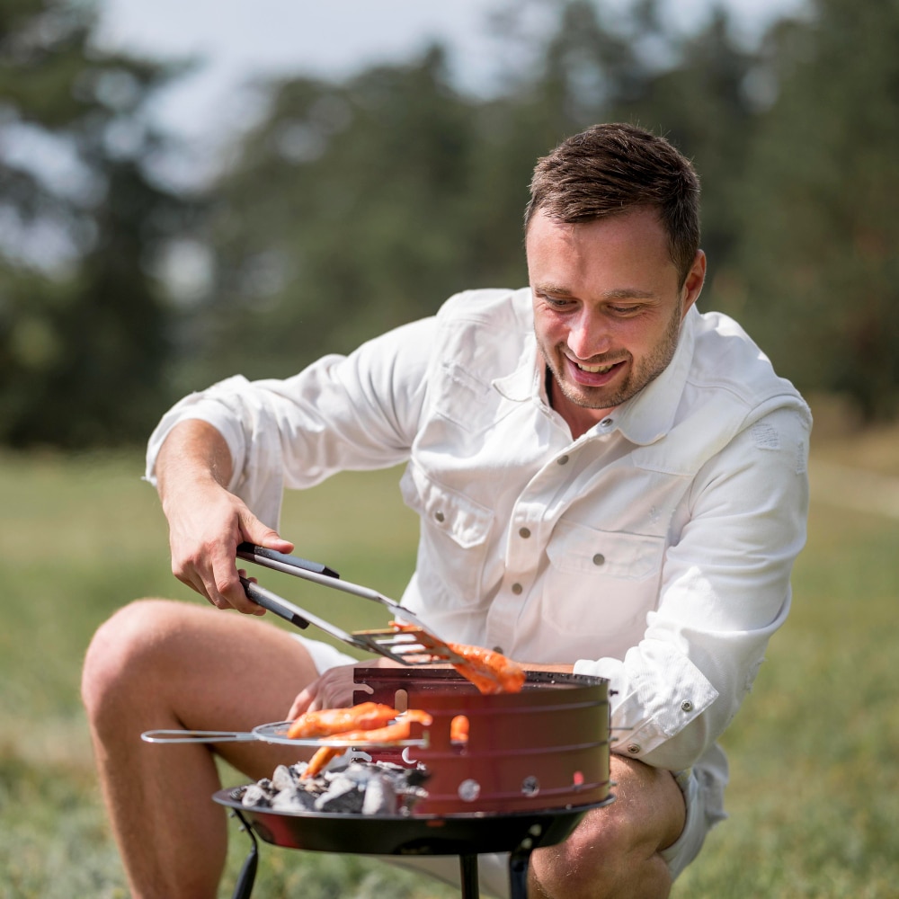 a man cooking the barbecue outdoors