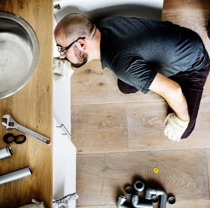a man fixing kitchen sink
