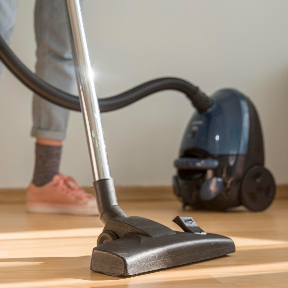 a woman cleaning the room with a vacuum cleaner